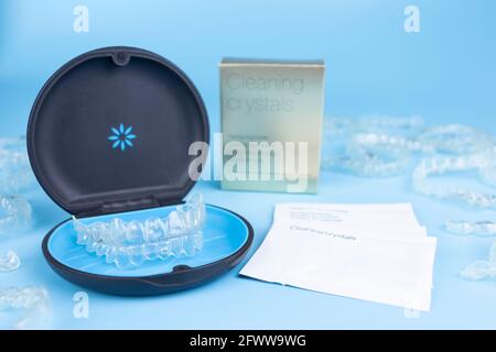 Unsichtbarer Halter mit kieferorthopädischen Ausrichterhalterungen. Schwarzer Kunststoff-Dentalbehälter für herausnehmbare invisalign-Zahnspangen auf blauem Hintergrund Stockfoto
