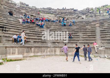 UMM QAIS, JORDANIEN - 30. MÄRZ 2017: Junge Touristen besuchen die Ruinen des West Theatre in Umm Qais Stockfoto