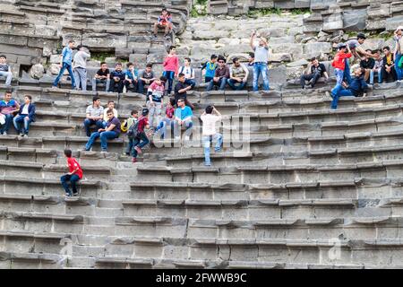 UMM QAIS, JORDANIEN - 30. MÄRZ 2017: Touristen besuchen die Ruinen des West Theatre in Umm Qais Stockfoto