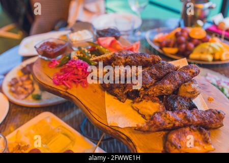 Traditioneller georgianischer lula Kebab mit drei Arten Sauce - Ketchup, grüne Tkemali, Mayonnaise. Selektiv fokussiert Stockfoto