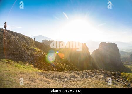Eine Frau genießt den Sonnenuntergang im Tal über Meteora, Griechenland Stockfoto