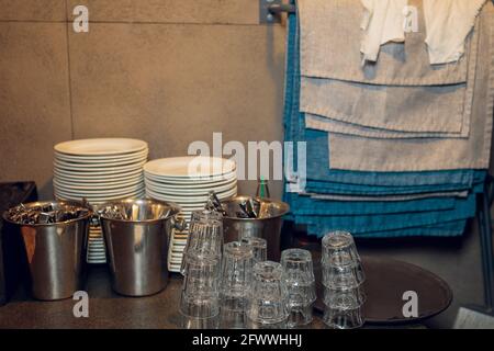 Der Kellner im Restaurant serviert einen Tisch aus nächster Nähe. Der Kellner serviert leeres Geschirr, Tischdecken. Die Kellnerin legt die Gabel, stellt den Tisch. Stockfoto