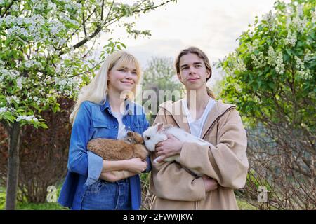 Jugendliche mit Kaninchen in den Händen, Haustiere ein paar dekorative Kaninchen Stockfoto