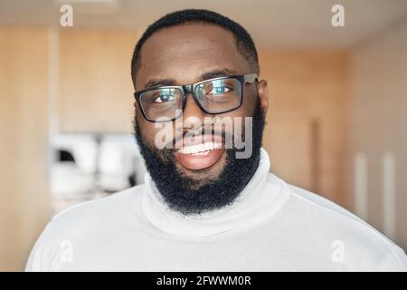 Nahaufnahme junger bärtiger afroamerikanischer Mann in einer Brille, der ihn ansieht Kamera Stockfoto