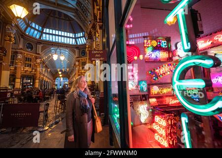 London, Großbritannien. 24 Mai 2021. Besucher, die Electric City, Gods Own Junkyard's Ausstellung von Hollywood Neon auf dem Leadenhall Market in London betrachten. Die Ausstellung wird am 26. Mai eröffnet und wird an verschiedenen Orten des Marktes mit Neonbeleuchtung ausgestattet sein. Bilddatum: Montag, 24. Mai 2021. Bildnachweis sollte lauten: Matt Crossick/Empics/Alamy Live News Stockfoto