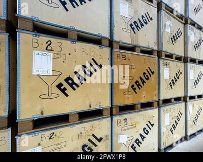 Holzkisten, die in einem Lager mit der Botschaft „FRAGILE“ auf Spanisch gestapelt wurden, Holzkisten, Verpackungsmaterial für empfindliche Produkte Stockfoto