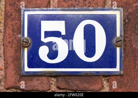 Nummer 50 in weiß auf einer blauen Metallplatte Stockfoto