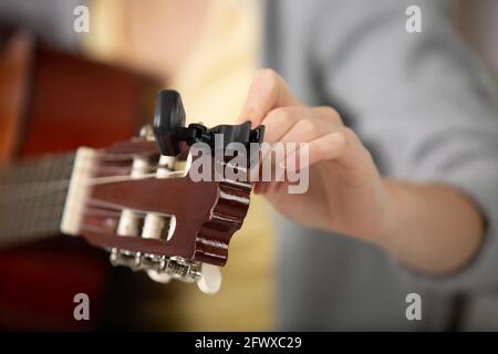 Nahansicht einer weiblichen Hand, die eine Gitarre stimmt Stockfoto