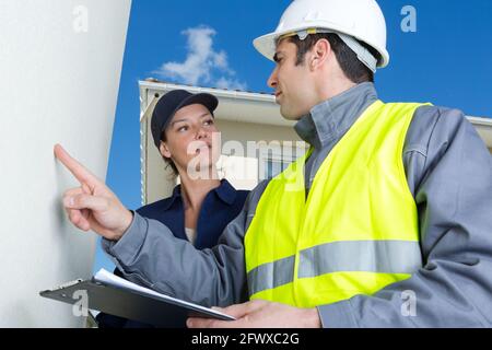 Bauarbeiter überprüfen die Wand Stockfoto