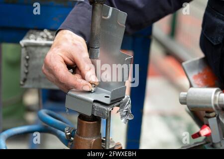 Nahaufnahme eines Metallelements, das von einem Fabrikarbeiter punktgeschweißt wird. Branchenkonzept. Hochwertige Fotos Stockfoto