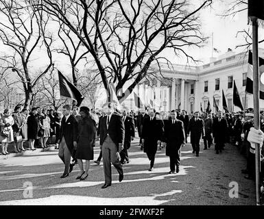 Mitglieder der Kennedy-Familie und andere gehen in der Trauerprozession von Präsident John F. Kennedy zur Kathedrale von St. Matthew the Apostle. Zu den Spaziergängen gehören: Generalanwalt Robert F. Kennedy; Jacqueline Kennedy; Senator Edward M. Kennedy (Massachusetts); Jamie Auchincloss (teilweise verborgen); Direktor des Friedenskorps, R. Sargent Shriver; Steve Smith; Präsident Lyndon B. Johnson; First Lady Bird Johnson; Lucy Baines Johnson; Geheimagenten des Weißen Hauses, Clint Hill, Paul Landis, Toby Chandler, Stu Stout, Und James J. Rowley. Trauernde und Mitglieder der Farbschutzlinie Stockfoto