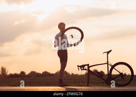 Bärtiger Mann im Sportoutfit Einstellrad auf dem Fahrrad Stockfoto