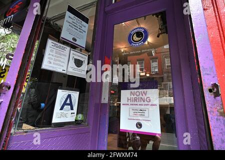 New York, USA. Mai 2021. Ein „Now Hiring“-Zeichen für mehrere Stellen ist an der Eingangstür von „Insomnia Cookies“, New York, NY, 24. Mai 2021, angebracht. Bestimmte Einzelhändler kämpfen auf dem „post-pandemischen“ Markt darum, Arbeitsplätze zu besetzen, da das Beschäftigungswachstum in den Vereinigten Staaten nach den Arbeitgeberdaten für den Monat April zu verlangsamen scheint, da weniger Arbeitsplätze im Vergleich zum Monat März hinzugefügt wurden. Einige Unternehmer glauben, dass die Arbeitslosenunterstützung von 300 Dollar pro Woche von der Aufnahme neuer Arbeitsplätze abhält. (Foto von Anthony Behar/Sipa USA) Quelle: SIPA USA/Alamy Live News Stockfoto