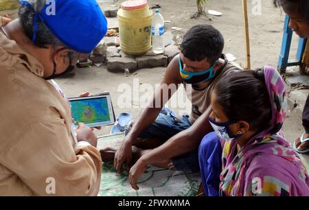 Kalkutta, Indien. Mai 2021. Ein Freiwilliger illustriert den Weg eines bevorstehenden Wirbelsturms zu Obdachlosen in Kalkutta, Indien, am 24. Mai 2021. Quelle: Str/Xinhua/Alamy Live News Stockfoto