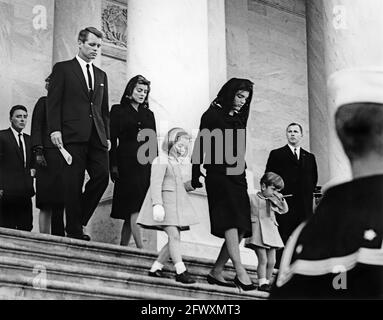 First Lady Jacqueline Kennedy und ihre Kinder, Caroline Kennedy und John F. Kennedy, Jr., verlassen das US-Kapitolgebäude, wo der verstorbene Präsident John F. Kennedy im Bundesstaat liegt. Im Hintergrund: Peter Lawford; Generalanwalt, Robert F. Kennedy; Patricia Kennedy Lawford. Washington, D.C. Stockfoto