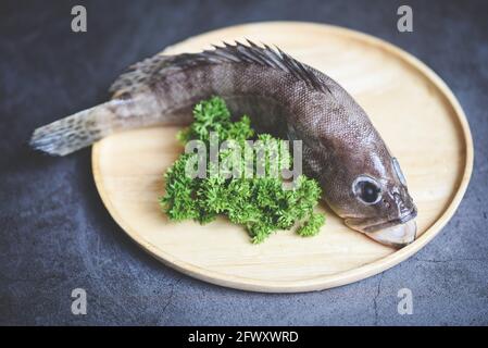 Zackenbarsch auf Holzplatte, frischer roher Fisch für gekochte Speisen Stockfoto