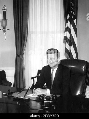 Portraitfoto von Präsident John F. Kennedy an seinem Schreibtisch im Oval Office, White House, Washington, D.C. Dies ist das erste Foto des Präsidenten im Weißen Haus an seinem Schreibtisch. Stockfoto