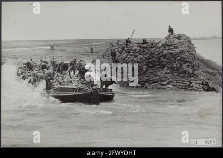 Hochwasserkatastrophe 1953. Loch im Deich bei Herkingen am Goeree-Overflakkee ist verstopft. Dachbohnen mit Basaltblöcken werden in das Loch gesegelt und so schnell wie möglich entladen, 12. März 1953, Deiche, Reparaturarbeiten, Hilfsmaßnahmen, Landschaften, Naturstein, Überschwemmungen, Katastrophen, Niederlande, Presseagentur des 20. Jahrhunderts, Foto, Nachrichten zum erinnern, Dokumentarfilm, historische Fotografie 1945-1990, visuelle Geschichten, Menschliche Geschichte des zwanzigsten Jahrhunderts, Momente in der Zeit festzuhalten Stockfoto