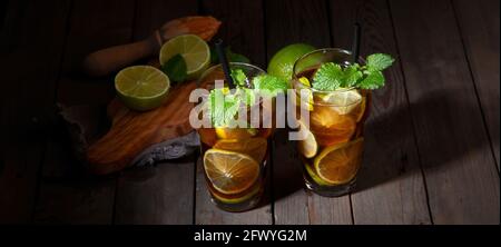 Frisch zubereitetes Longdrink Cuba Libre Cocktail auf dunklem Hintergrund. Panorama Stockfoto