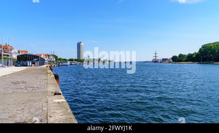 Travemünde, Schleswig-Holstein, Deutschland - 17. Juni 2020: Blick auf die Trave mit dem Kreuzfahrtterminal auf der linken Seite und dem alten Leuchtturm in Stockfoto