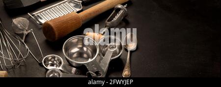 Set von Küchenutensilien auf schwarzem Hintergrund. Werkzeuge zum Kochen. Panorama Stockfoto