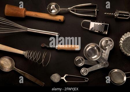Set von Küchenutensilien auf schwarzem Hintergrund. Werkzeuge zum Kochen. Draufsicht Stockfoto