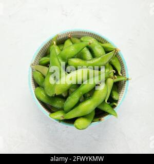 Rohe Sojabohnen mit Edamame und Salz und Sauce auf hellgrauem Hintergrund. Draufsicht Stockfoto