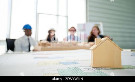 Nahaufnahme Gebäude Modell-Projekt auf dem Tisch mit Menschen treffen sich im Hintergrund. Immobilien Geschäftskonzept. Stockfoto