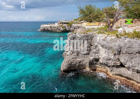 Karibischer Strand mit Felsen und türkisfarbenem Wasser in Negril, Jamaika Stockfoto