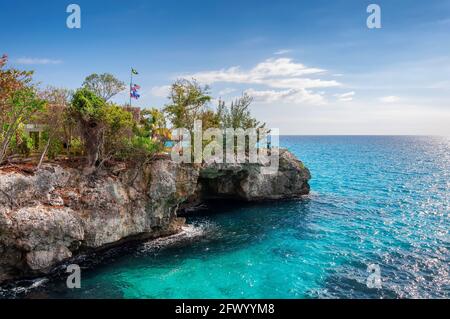 Karibischer Strand mit Felsen und türkisfarbenem Wasser in Negril, Jamaika Stockfoto