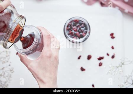 Gesundes fermentiertes Honigprodukt mit Cranberry. Gärung Honigprozess.Lebensmittelkonservierungsmittel zu Hause, gemütlich, rustikal flach legen. Köstliches Rezepturkonzept. Antivirale Nahrung. Antibakterielles, antivirales Produkt Stockfoto