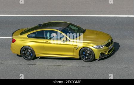 2014 BMW M4 gelbes 2978cc Benzincoupé; Fahrzeugverkehr, bewegliche Fahrzeuge, Autos, Fahrzeug auf britischen Straßen, Motoren, Fahren auf der Autobahn M6, britisches Straßennetz. Stockfoto