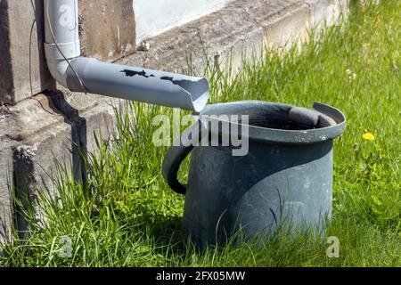 Ein voller Regenwassertank unter der Rinne Stockfoto