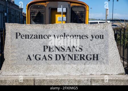 Ein großes Granitstück sagt, dass Penzance Sie willkommen heißt, PENSANS A'GAS DYNERGH in Penzance, Cornwall, Großbritannien, mit einem Zugwagen dahinter Stockfoto