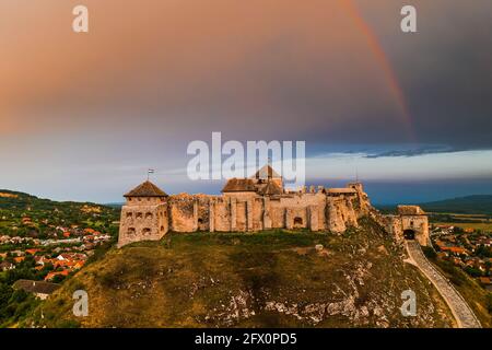 Sumeg, Ungarn - Luftpanorama auf die berühmte hohe Burg von Sumeg in Veszprem Grafschaft bei Sonnenuntergang mit Sturmwolken und Regenbogen oben an einem Sommer Stockfoto