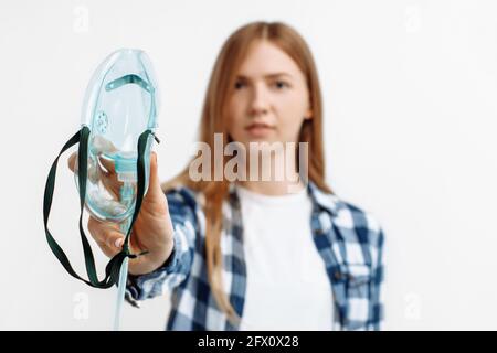 Porträt einer jungen Frau mit Sauerstoffmaske, Frau hat Atembeschwerden, Behandlung auf isoliertem weißem Hintergrund Stockfoto