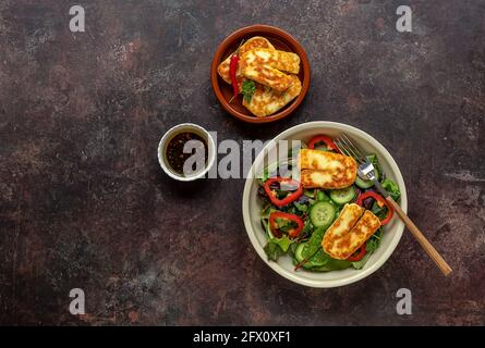 Grüner vegetarischer Salat aus grünem Laubmix, Gemüse und Halloumi-Käse. Gesundes Rezept. Stockfoto
