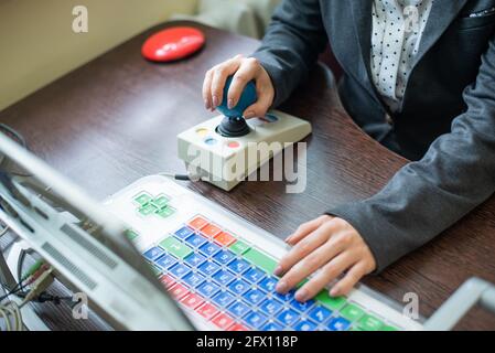 Frau mit zerebraler Lähmung arbeitet an einem spezialisierten Computer. Stockfoto