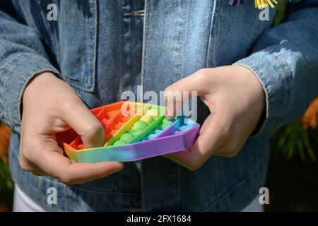 Mädchen spielen in sensorischen Anti-Stress Pop IT in Hexagon-Form Spielzeug. Nahaufnahme. Stockfoto