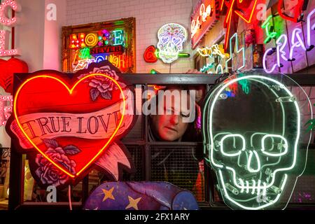 London, Großbritannien. 25 Mai 2021. Marcus Bracey bei der Vorschau von „Electric City“, einer Ausstellung im Leadenhall Market mit Neon- und Versatzstücken, die von Gods own Junkyard für Film gemacht wurden und seit über 40 Jahren an Filmsets arbeitet. Der Gründer Chris Bracey verstarb 2014 und das Unternehmen wird seitdem von seiner Frau Linda und den Söhnen Matthew und Marcus, allesamt Neon-Hersteller und -Designer, geführt. Die Leuchtreklame ist vom 26. Mai bis 31. Juli zu sehen. Kredit: Stephen Chung / Alamy Live Nachrichten Stockfoto