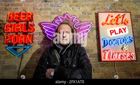 London, Großbritannien. 25 Mai 2021. Marcus Bracey bei der Vorschau von „Electric City“, einer Ausstellung im Leadenhall Market mit Neon- und Versatzstücken, die von Gods own Junkyard für Film gemacht wurden und seit über 40 Jahren an Filmsets arbeitet. Der Gründer Chris Bracey verstarb 2014 und das Unternehmen wird seitdem von seiner Frau Linda und den Söhnen Matthew und Marcus, allesamt Neon-Hersteller und -Designer, geführt. Die Leuchtreklame ist vom 26. Mai bis 31. Juli zu sehen. Kredit: Stephen Chung / Alamy Live Nachrichten Stockfoto