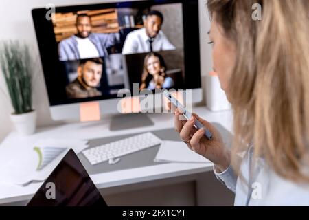 Nahaufnahme einer erfolgreichen Geschäftsfrau hält von zu Hause aus eine Konferenz ab, spricht am modernen Telefon, diskutiert online mit Kollegen über ein erfolgreiches Projekt Stockfoto