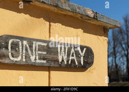 In der Ecke der Wand auf dem Schild die Inschrift „One Way“ ist keine Marke auf dem Hintergrund von Der blaue Himmel Stockfoto