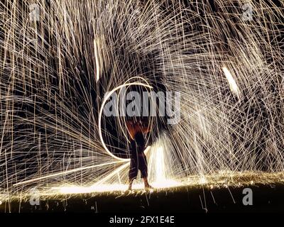 Firestarter, der eine tolle Feuershow mit Funkeln in der Nacht vorführt Stockfoto