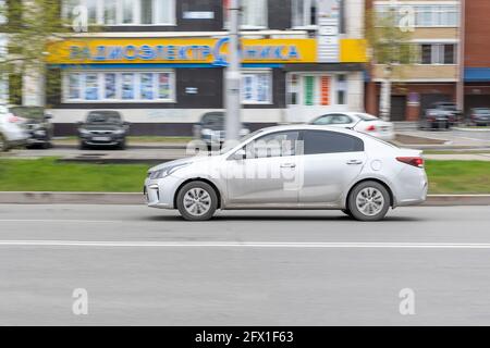 Graues Auto fährt die Straße hinunter in der Stadt. Bewegungsunschärfe. In der Stadt des Tages. Seitenansicht. Surgut, Russland - 17, Mai 2021. Stockfoto