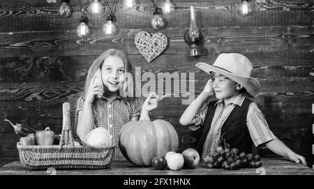 Kinder präsentieren Bauernhof Ernte hölzernen Hintergrund. Gründe, warum jedes Kind die Landwirtschaft erleben sollte. Verantwortlich für die täglichen landwirtschaftlichen Arbeiten. Kinder Stockfoto