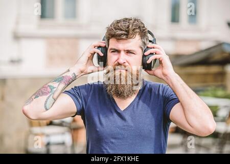 Reifer Hipster mit Bart, der Musik hört. Mann sitzend Hörmusik Kopfhörer Konzept. Brutal kaukasischen Hipster mit Schnurrbart. Genießen Sie seine Stockfoto