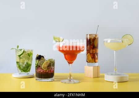 Klassischer Mojito, cuba Libre, margarita Cocktail mit Limette und Zitrone auf modernem blau-gelbem Hintergrund. Fünf Sommer Frische Getränk für festliche pa Stockfoto