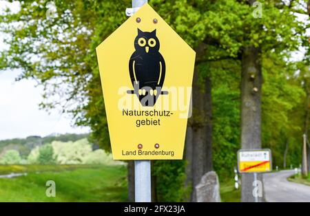 19. Mai 2021, Brandenburg, Rühstädt: Ein Schild auf einer Wiese im Storchdorf Rühstädt im Prignitz-Gebiet der UNESCO-Biosphärenreservat Elbe-Brandenburg weist auf das Naturschutzgebiet hin. Als eine der größten Storchenkolonien Mitteleuropas trägt Rühstädt den Titel „Europäisches Storchendorf“. Foto: Jens Kalaene/dpa-Zentralbild/ZB Stockfoto