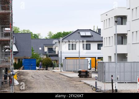 Oranienburg, Deutschland. Mai 2021. Die von der Oranienburger Wohnungsbaugesellschaft (WOBA) in der Weißen Stadt an der Emil-Büge-Straße/Ecke Walther-Bothe-Straße errichteten neuen mehrstöckigen Gebäude sind im Rohbau oder fast bezugsfertig. Im Hintergrund sind die Einfamilienhäuser in der Johannes-Rau-Straße zu sehen. Quelle: Soeren Stache/dpa-zentralbild/dpa/Alamy Live News Stockfoto